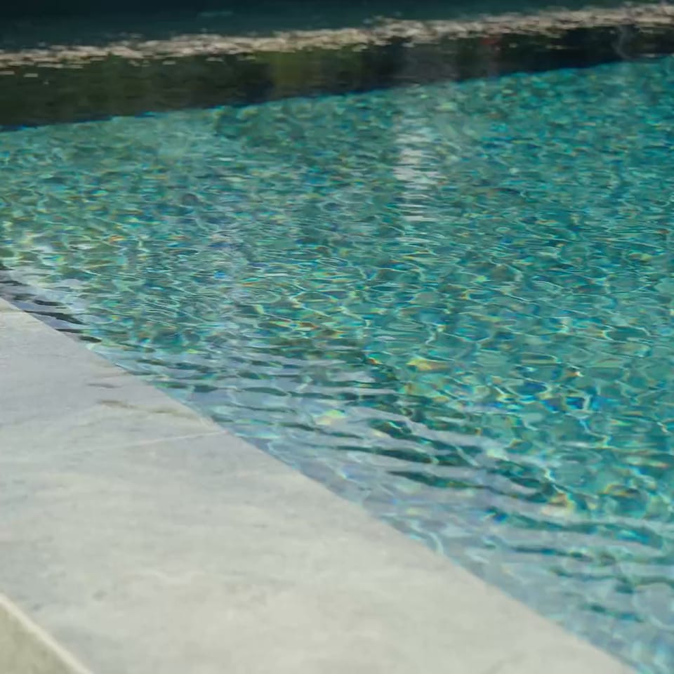 Rippling pool water with the country house beyond